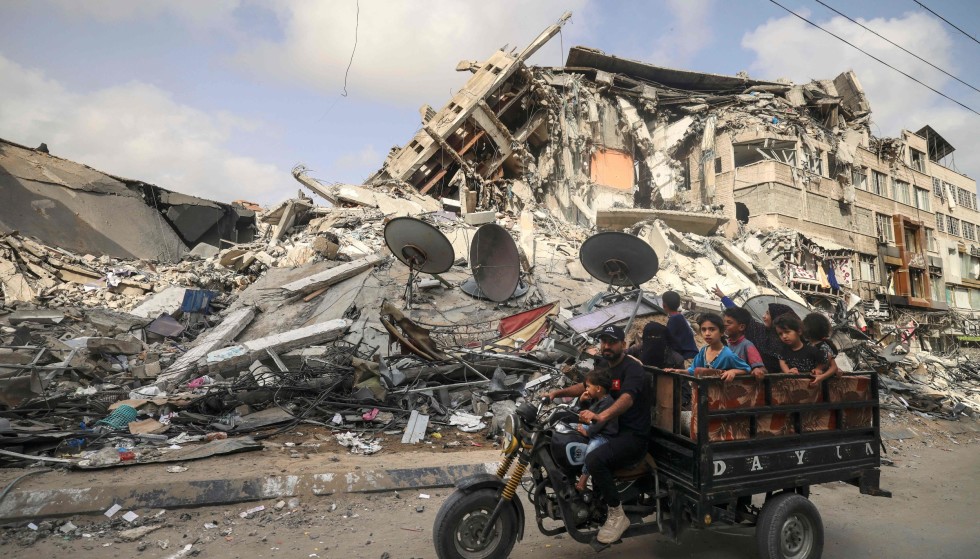 Ceasefire: A man carrying children in front of a building that was bombed by Israel this week before the ceasefire.  Photo: Mahmoud Homs / AFP / NTB