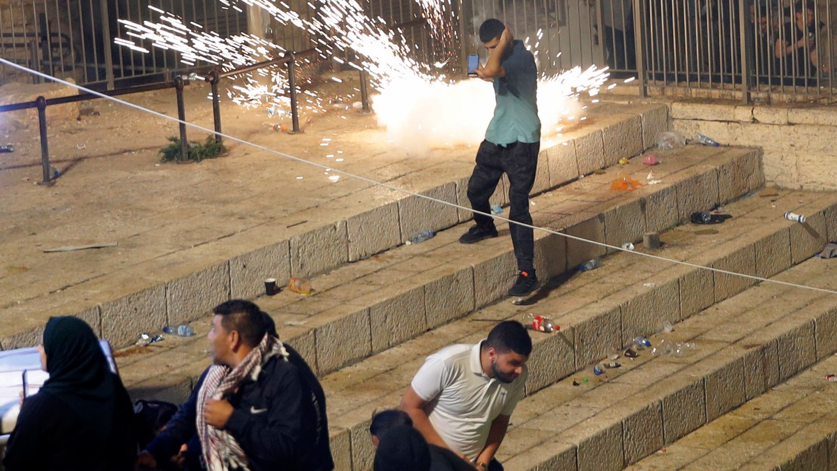 Palestinere løper fra sjokkgrenader avfyrt av israelske politistyrker i Jerusalems gamleby lørdag